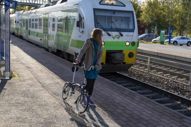 Nainen odottaa Oriveden asemalla junaa taittopyöränsä kanssa. Hän on matkalla Tampereelle.