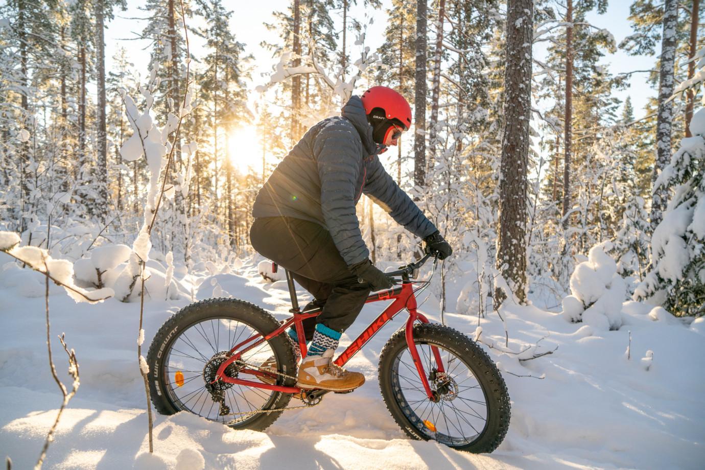 Mies pyöräilee fatbike-pyörällä talvisella Paltanmäellä Orivesi-JonSukat jalassaan.