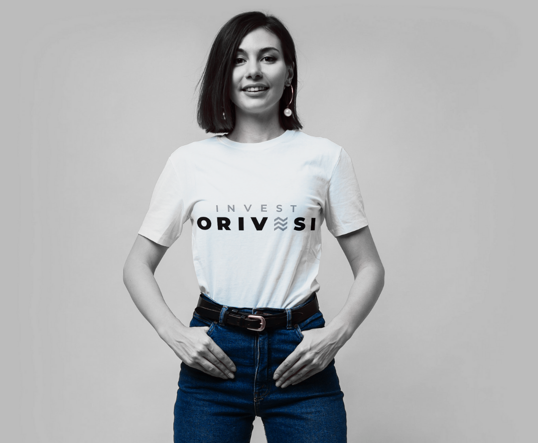 Nainen, jonka valkoisessa t-paidassa lukee Invest Orivesi.