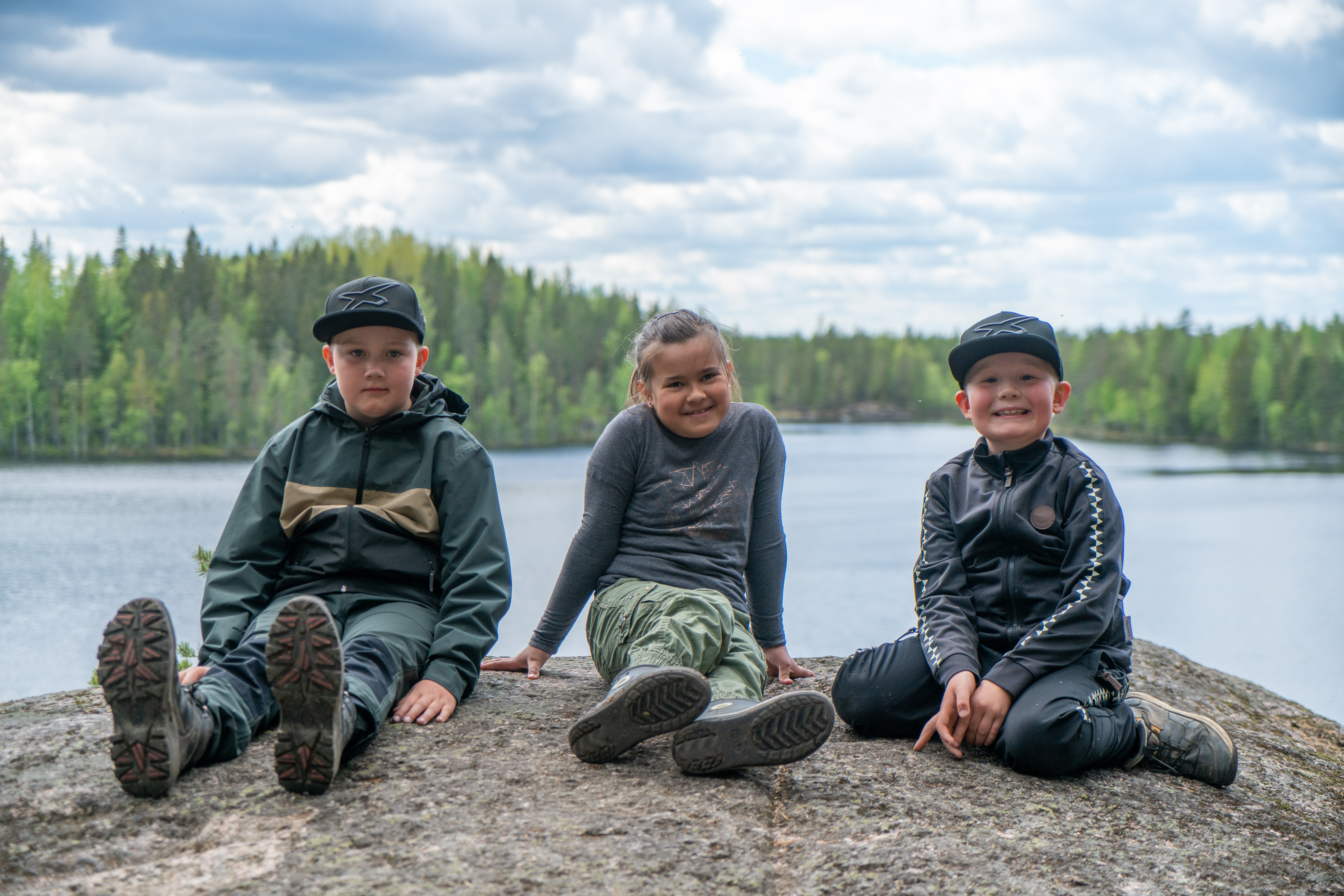 Lapsia istumassa Iso-Vuorijärven rantakalliolla.